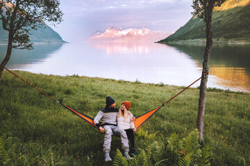 Couple friends chilling in hammock together man and woman traveling together in Norway family...
