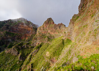 Beautiful mountain landscape view with vibrant colors during a sunny day. Hiking trail of Pico Arieiro to Pico Ruivo, Madeira Island Portugal. Travel the world. Nomad life. Adventurous lifestyle.
