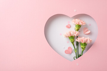 Mother's Day serenity concept. Top view of fragrant carnations, heartfelt cards, seen through heart...