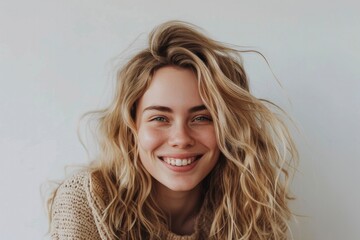 Sunlit portrait of a joyful woman with tousled blonde hair and a hearty laugh, wrapped in a cozy sweater - obrazy, fototapety, plakaty