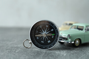 A compass on a table with a car.