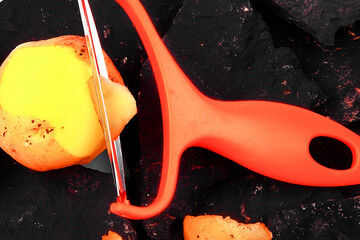 Slicing potatoes. Potato peeler. on a white isolated background. Slicer. Professional vegetable...