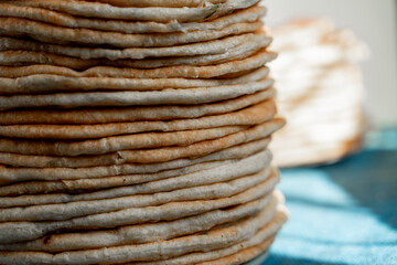 Flatbread lavash, chapati, naan, heap of tortilla on a blue background Homemade flatbread stacked.