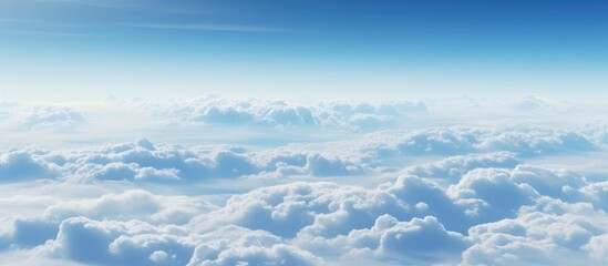 Fototapeta premium An aerial view of cumulus clouds decorating the sky, creating a stunning natural landscape as seen from the airplane window