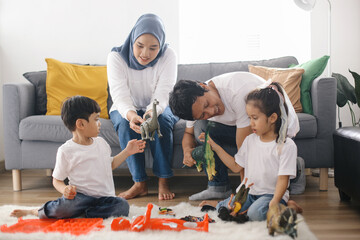 Parents with Two Kids Playing Toys Together at Living Room. Happy Family Bonding at Home. - obrazy, fototapety, plakaty