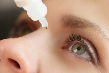 Close-up of woman applying medical eye drops against diseases.