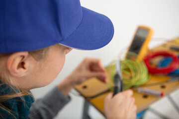 man with multimeter checking voltage in a wall fixture