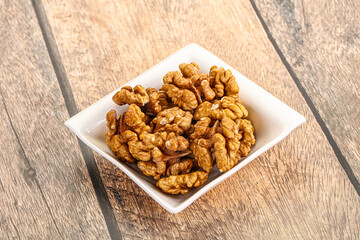 Cracked unshelled walnut in the bowl