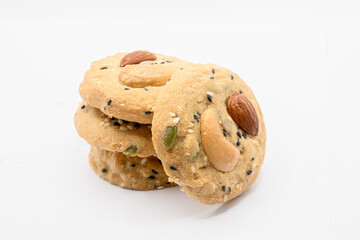 Stack of Whole Grain Cookies with different seeds, cashew nuts, almond, black sesame, pumpkin seed on white background