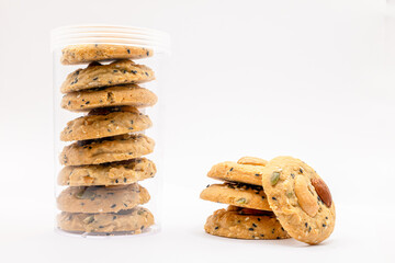 Stack of Whole Grain Cookies with different seeds, cashew nuts, almond, black sesame, pumpkin seed on white background with copy space