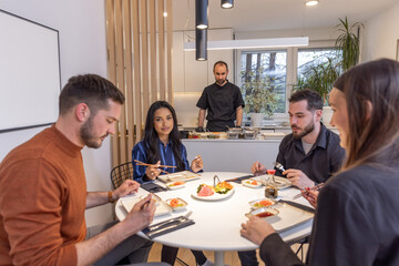 Group of people having dinner with private chef at home