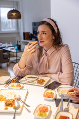 Happy woman eating steak tartare at home - 769498337
