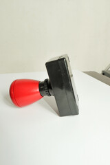 Red rubber stamp on a white background. Shallow depth of field.