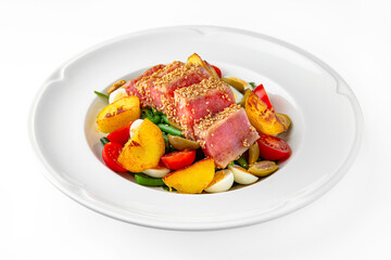 Light diet salad. Tuna seared in sesame seeds with vegetables and herbs on a white plate. Banquet festive dishes. Gourmet restaurant menu. White background.