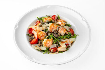 Easy diet salad with shrimp, pumpkin seeds and greens  on a white plate. Banquet festive dishes. Gourmet restaurant menu. White background.