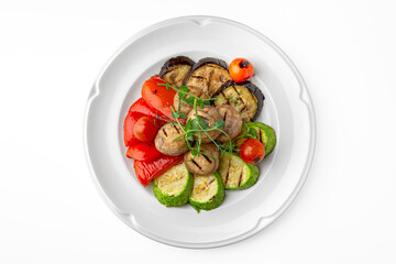 Grilled vegetables: peppers, mushrooms, zucchini on a white plate. Banquet festive dishes. Gourmet restaurant menu. White background.