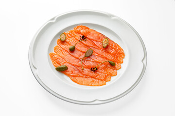 Slices of delicatessen salmon and capers on a white plate. Banquet festive dishes. Gourmet restaurant menu. White background.