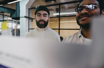 Happy young bearded men working in office