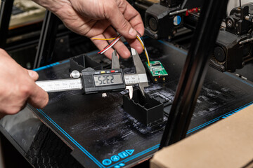 Engineer measures part created on 3D printer