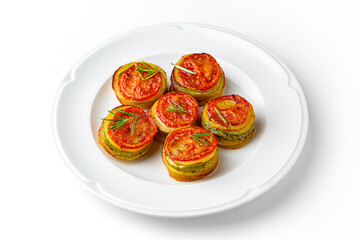 Ratatouille of zucchini circles, eggplant, tomato on a white plate. Banquet festive dishes. Gourmet restaurant menu. White background.