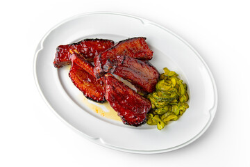 Pork loin or bone-in pork baked in the oven with pickles on a white plate. Banquet festive dishes. Gourmet restaurant menu. White background.