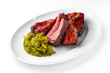 Pork loin or bone-in pork baked in the oven with pickles on a white plate. Banquet festive dishes. Gourmet restaurant menu. White background.