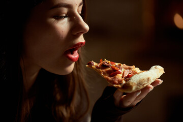 Girl with red lipstick sexy eating pizza in a pizzeria