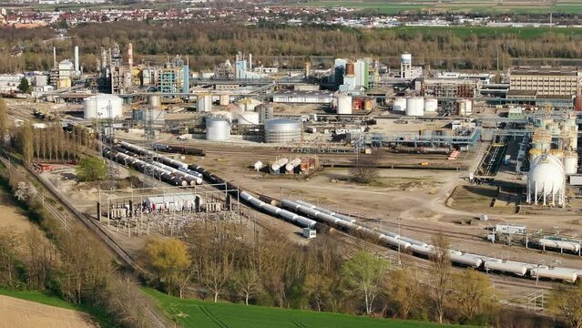 Aerial shot of Alsachemie rail station with trains amid industrial background, daylight