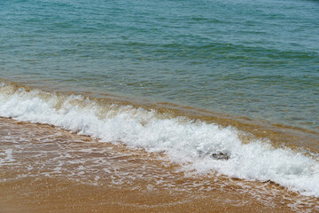 Soft wave of blue water of Black sea on sandy beach.