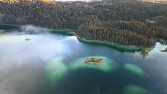 Aerial footage with a drone of a beautiful, stunning lake Eibsee in Germany, during autumn.