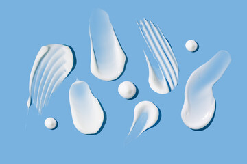 composition of smears of cream texture on a blue background