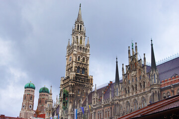 Fototapeta na wymiar New city hall and towers of Frauenkirche Cathedral (left) in Munich, Bavaria, Germany