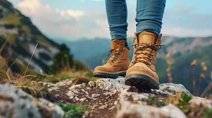 Poster Füße in Wanderstiefeln stehen auf einem hohen Berg. Wander- und Freiheitskonzept. Hintergrund für Design. © Evgeniia