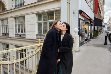 Intimate moment of happy lesbian women in love standing together on street in European city