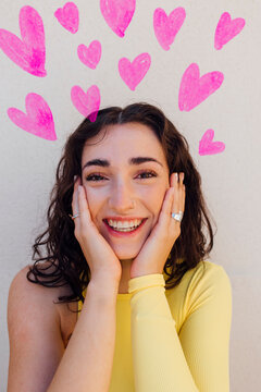 Happy woman with heart doodles against white background