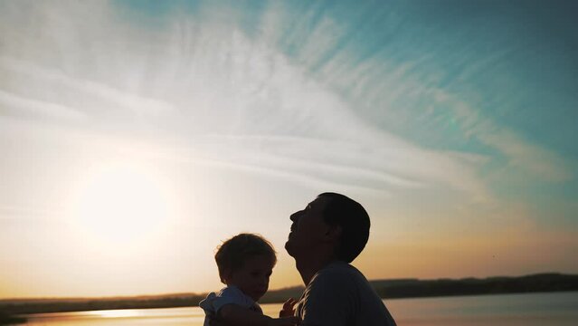 Happy family concept. silhouette of father with child on his back at sunset. father's day Dad and child relax together on the weekend in nature. father plays with baby in the fresh air.happy childhood