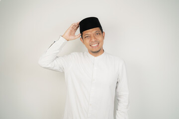 Asian Muslim man thinking about something touching his chin, wearing Arab costume at copy space on isolated background - obrazy, fototapety, plakaty