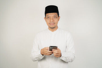 Asian Muslim man happy what he see in the smartphone on isolated background - obrazy, fototapety, plakaty