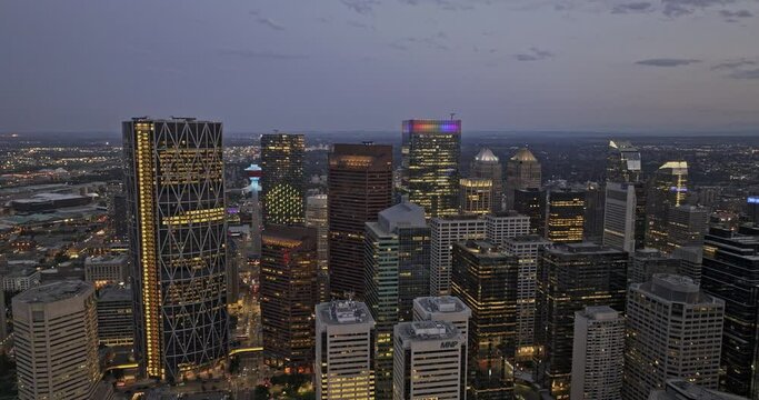 Calgary AB Canada Aerial v67 drone flyover and around downtown commercial capturing cityscape of towering skyscrapers with light up building exterior at dusk - Shot with Mavic 3 Pro Cine - July 2023