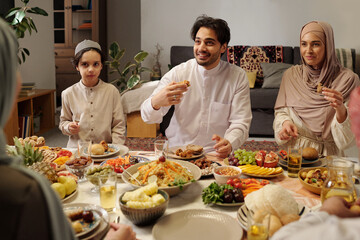 Muslim Family Enjoying Dinner In Majilis - obrazy, fototapety, plakaty