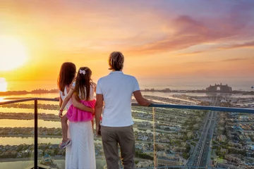 Foto op Plexiglas A family on holidays enjoys the beautiful view of The Palm island in Dubai, UAE, during a golden sunset © moofushi
