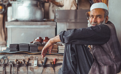 Poor old Pakistani cobbler sitting in his street shop