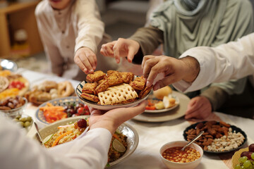 Obraz na płótnie Canvas Unrecognizable Muslim Man Offering Cookies During Dinner