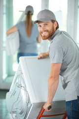 worker looking at camera after carrying washing machine