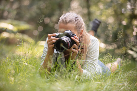 female photographer laying on the grass