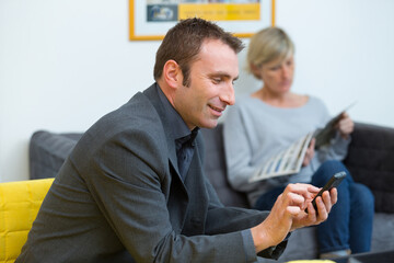 man in waiting room using mobile phone