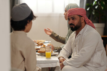 Middle Eastern Uncle Talking To Kid During Family Dinner - Powered by Adobe