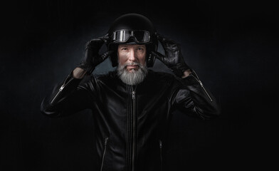 Portrait d'un motard homme avec un casque noir et une veste en cuir et des lunettes de protection...