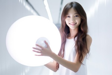 Naklejka premium Cute woman with LED round flash lamp in white glow. Moon lamp turn on and hold by two hands. Generative AI.