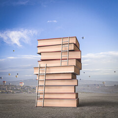 stack of books with ladders, background with hot air balloons. - 769571587